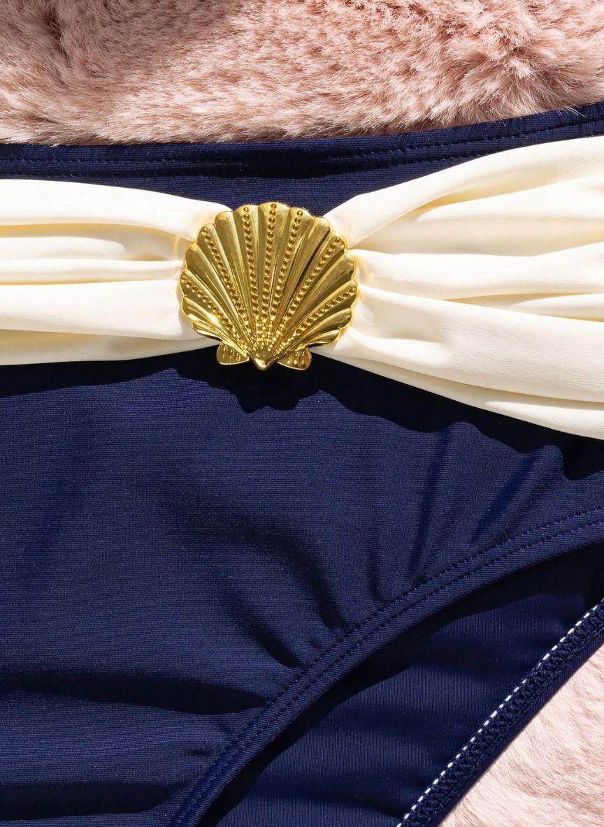 Biquíni Océan Naval Alizée, azul-marinho com drapeado off-white, concha dourada e top push-up. Elegante, cintura alta e perfeito para férias à beira-mar.