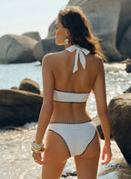 Biquíni Textury Mônica: tecido texturizado branco, aros dourados e cintura alta com laterais altas. Elegante, sensual e perfeito para praia e férias.