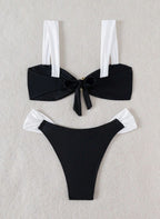 Biquíni Émilie. preto e branco elegante, alças grossas, laço nas costas e detalhe dourado central. Calcinha cheeky de cintura baixa. Sofisticação na praia.