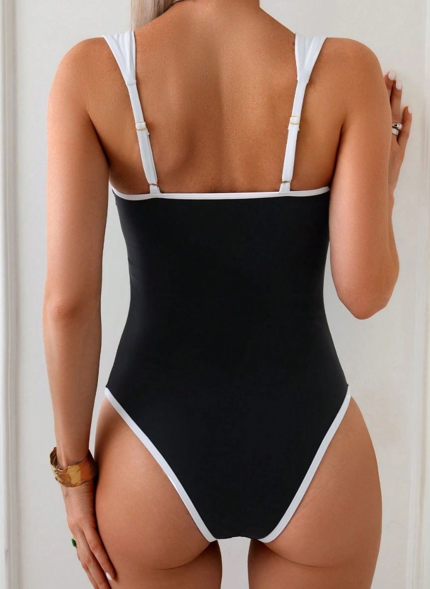 Eleve seu estilo com o Maiô Jacqueline, design clássico P&B, decote coração com argola dourada e costas abertas. O luxo atemporal para o seu verão. Confira.