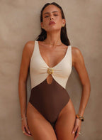 Maiô D’oro Atena: color block elegante, detalhe dourado e recorte vazado sutil. Modelagem com perna mais alta e bojo removível. Sofisticação para o verão.