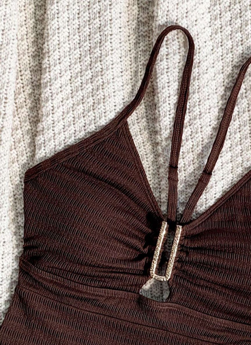 Eleve seu estilo com o Maiô Selina: tecido texturizado premium, detalhe em fivela de strass e design de costas abertas. O toque de luxo que seu verão merece. Confira.