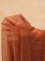 Saída Capucine, vestido solto em malha castanho, decote V profundo, mangas compridas e brilho metálico. Elegância fluida para praia, resort e férias.