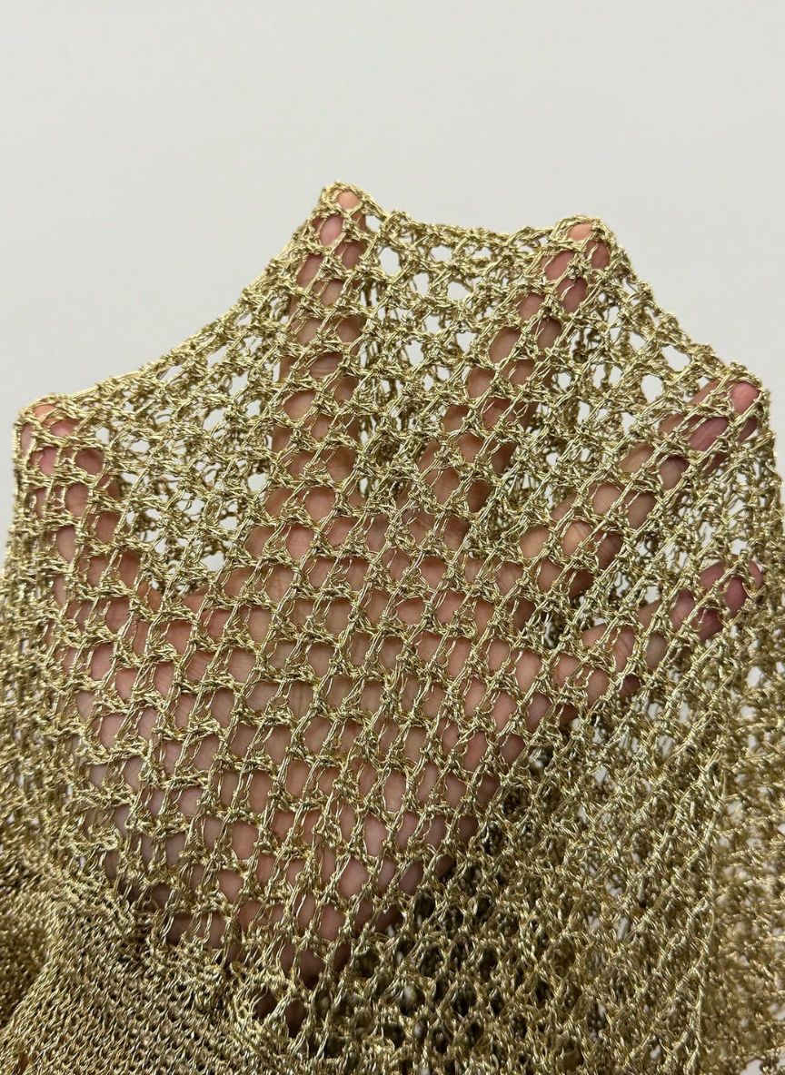 Vestido Darcy, tricô dourado vazado, gola alta drapeada, costas nuas e comprimento mini. Saída de praia luxuosa e iluminada para festas e férias à beira-mar.