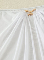 Saída de Praia Marselha, tecido malha slim fit, abertura lateral, nó ajustável e semi-transparente. O essencial sofisticado para transitar da praia ao resort.