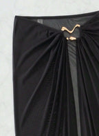 Saída de Praia Marselha, tecido malha slim fit, abertura lateral, nó ajustável e semi-transparente. O essencial sofisticado para transitar da praia ao resort.