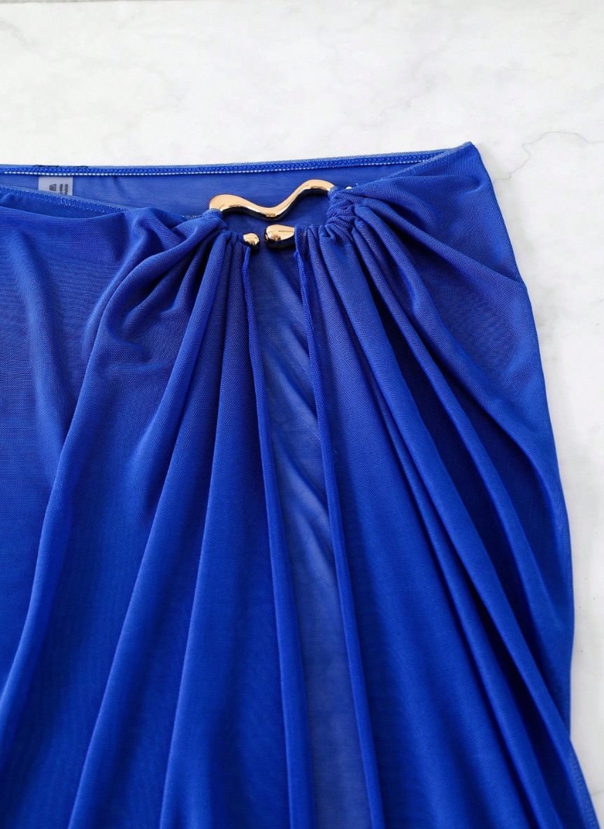 Saída de Praia Marselha, tecido malha slim fit, abertura lateral, nó ajustável e semi-transparente. O essencial sofisticado para transitar da praia ao resort.